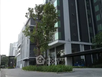 Modern high-rise building exterior with lush greenery and sleek design.