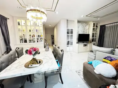 Luxurious living and dining area with elegant chandelier and marble table