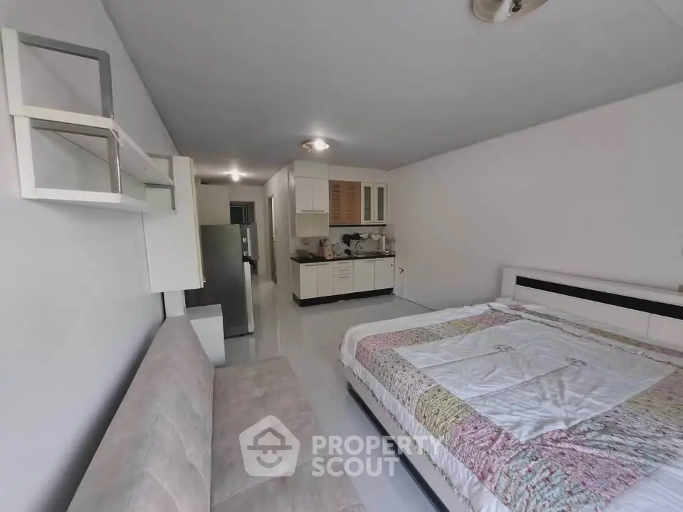 Spacious studio apartment with modern kitchen and cozy bed area, ideal for urban living.