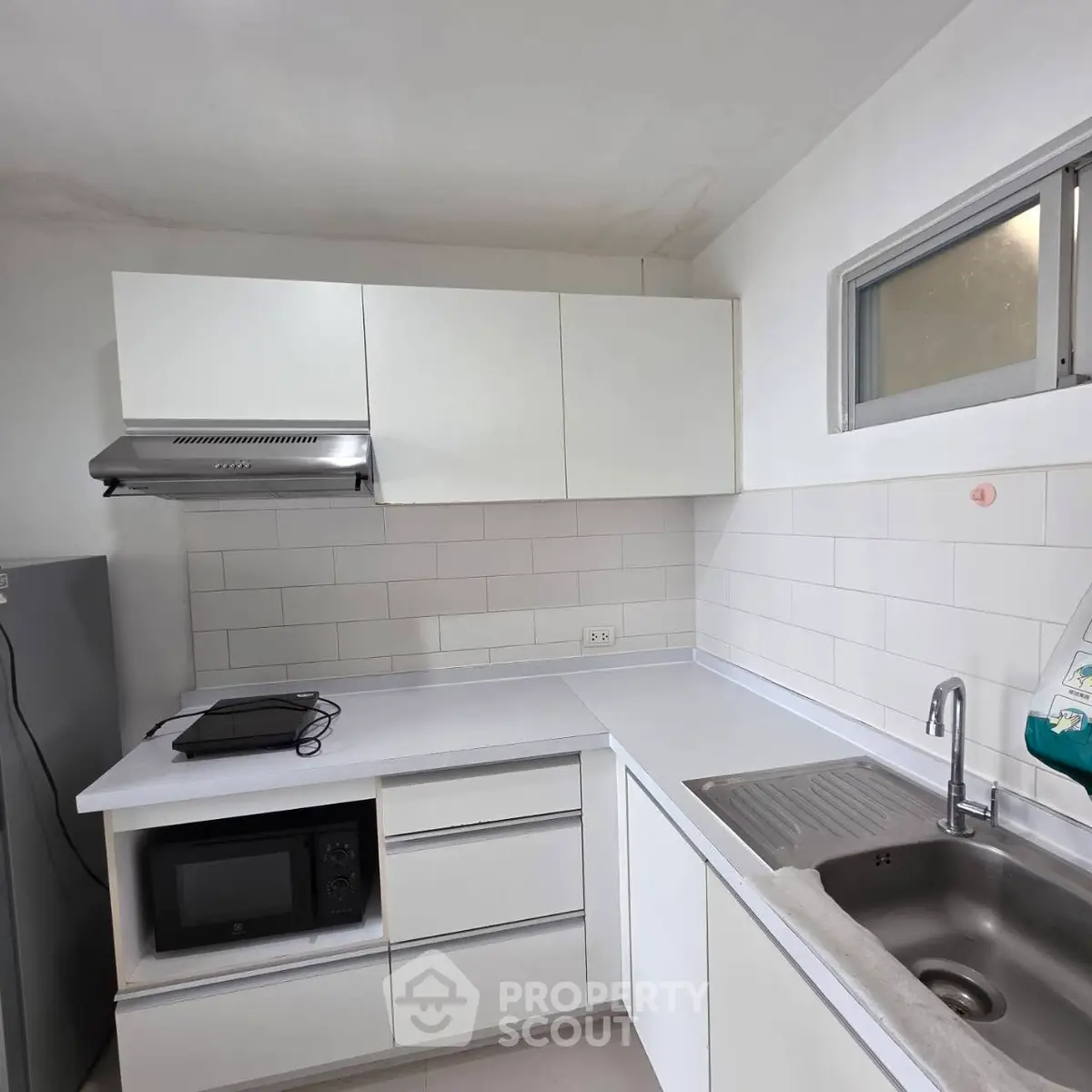 Modern kitchen with sleek white cabinets and stainless steel sink