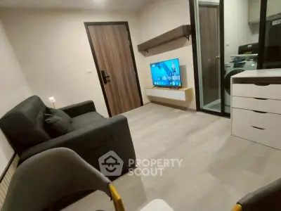 Modern living room with sleek furniture and wall-mounted TV in a cozy apartment.