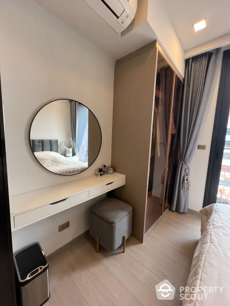 Modern bedroom with stylish vanity and large mirror, featuring elegant curtains and a cozy atmosphere.