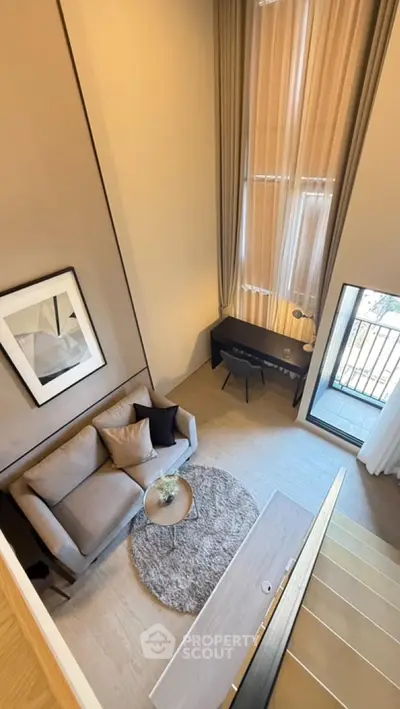 Modern loft-style living room with high ceilings and balcony view