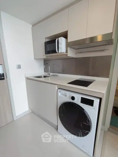 Modern compact kitchen with integrated appliances and sleek design