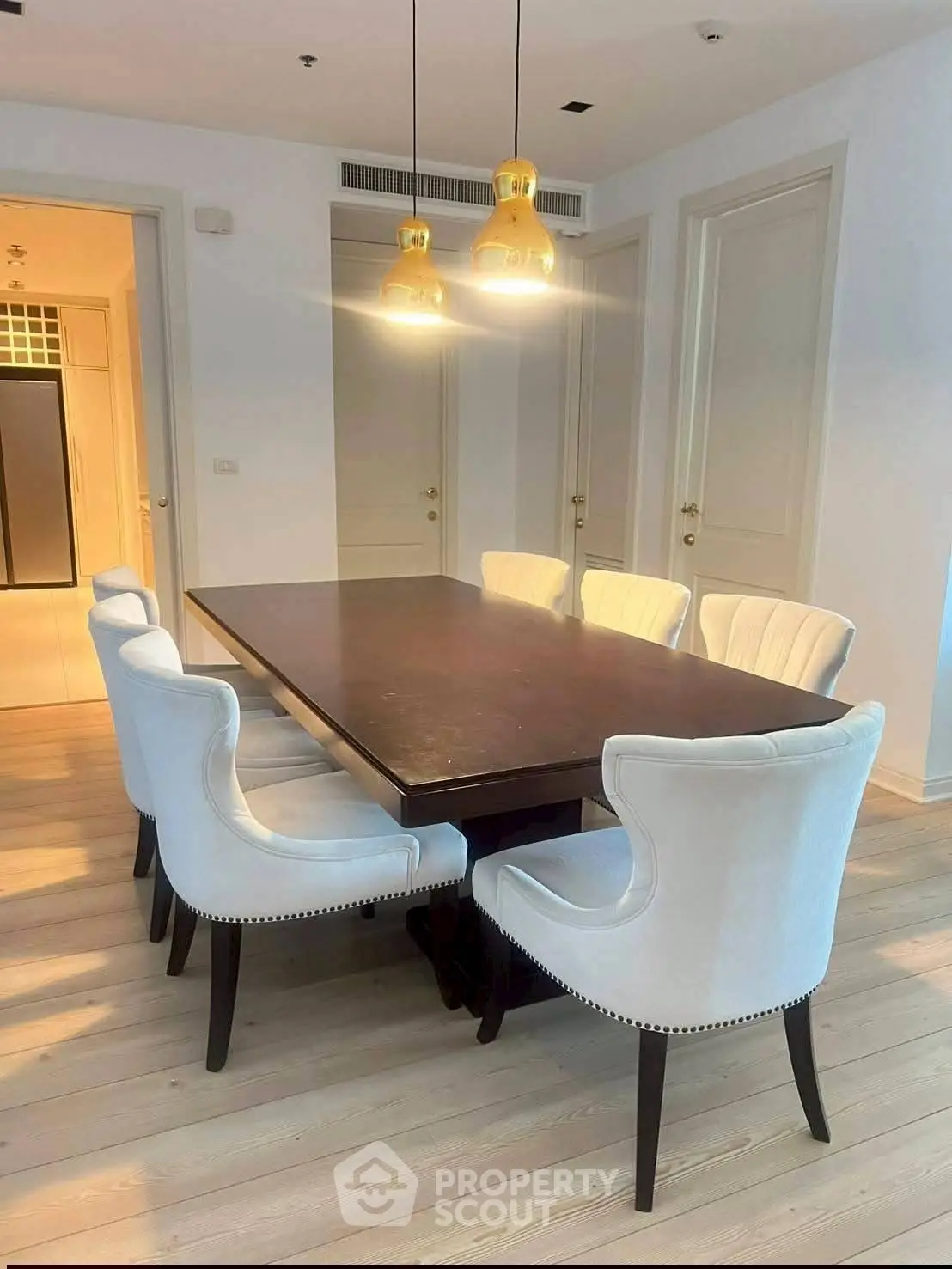 Elegant dining room with stylish chairs and modern lighting in a luxury apartment.