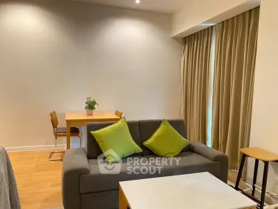 Modern living room with cozy sofa and dining area, featuring stylish decor and natural light.