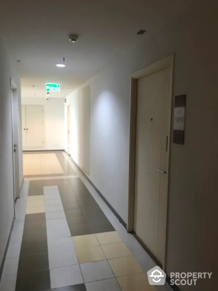 Modern apartment hallway with tiled flooring and room doors