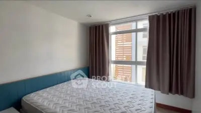 Spacious bedroom with large window and modern design in prime real estate location.