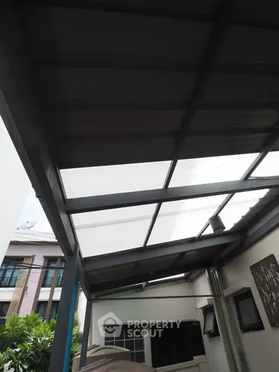 Modern covered patio area with sleek metal roofing and garden view