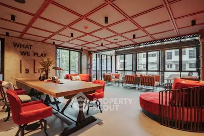 Luxurious modern living room with stylish red accents and large windows offering city views.