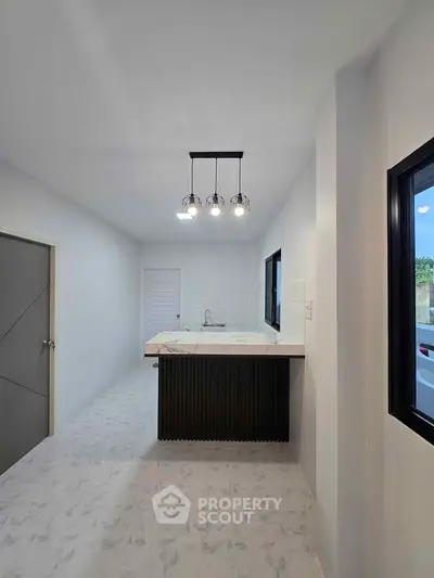 Modern kitchen with sleek design and stylish lighting in a contemporary home.
