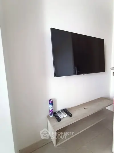 Modern living room with wall-mounted TV and minimalist wooden shelf