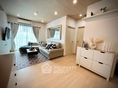 Modern living room with stylish decor, large window, and cozy seating area in a contemporary apartment.