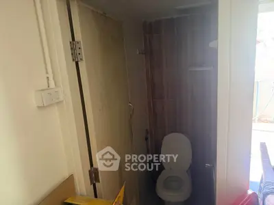 Compact bathroom with toilet and shower in a small space, ideal for efficient living.