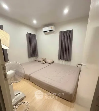 Cozy bedroom with air conditioning and minimalist decor, perfect for relaxation.