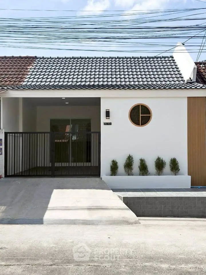 Charming single-story home with modern facade and gated entrance, perfect for cozy living.