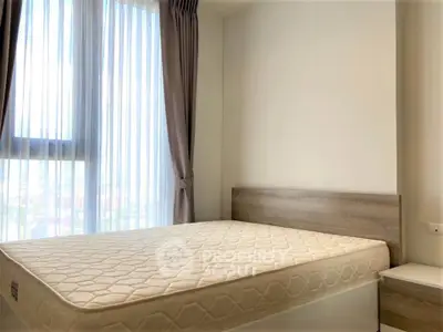 Bright and airy bedroom with large window and modern furnishings