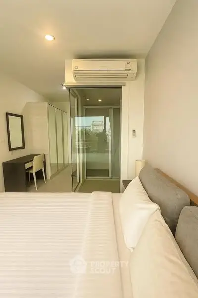 Modern bedroom with air conditioning and glass door to balcony