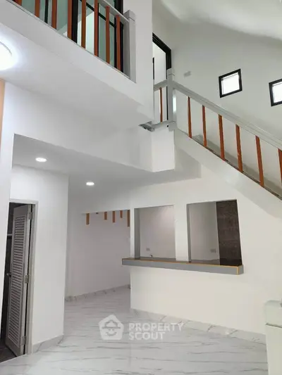 Modern interior with high ceilings and sleek staircase in a contemporary home.