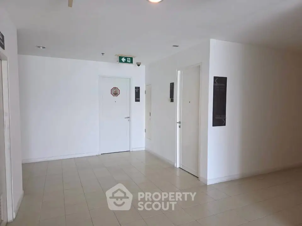 Spacious and clean apartment corridor with multiple doors and bright lighting.
