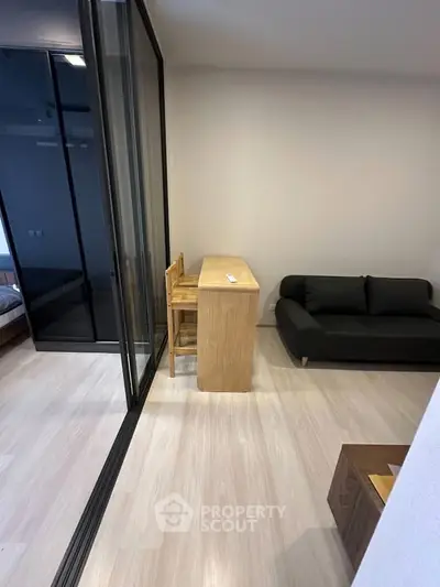 Modern living room with sleek glass partition and minimalist furniture