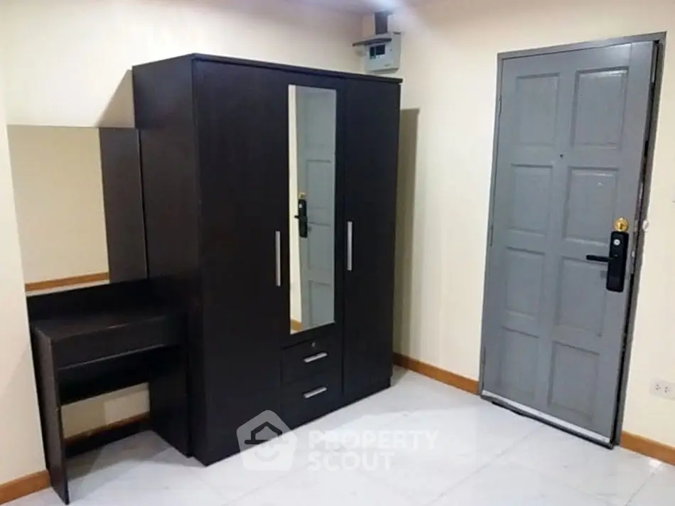 Modern bedroom with sleek wardrobe and secure door, perfect for stylish urban living.