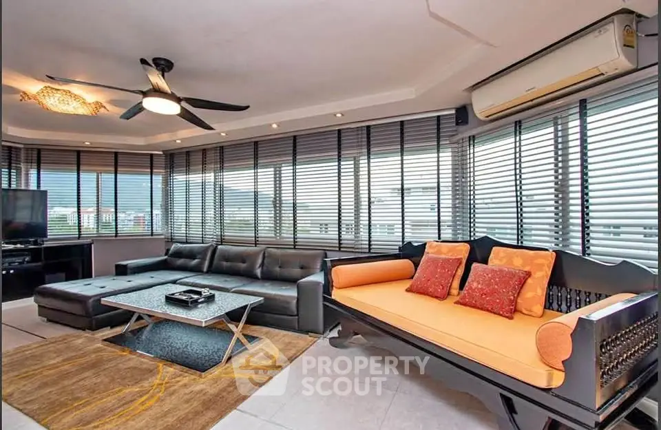 Spacious living room with panoramic windows and modern furnishings, perfect for relaxation and entertainment.