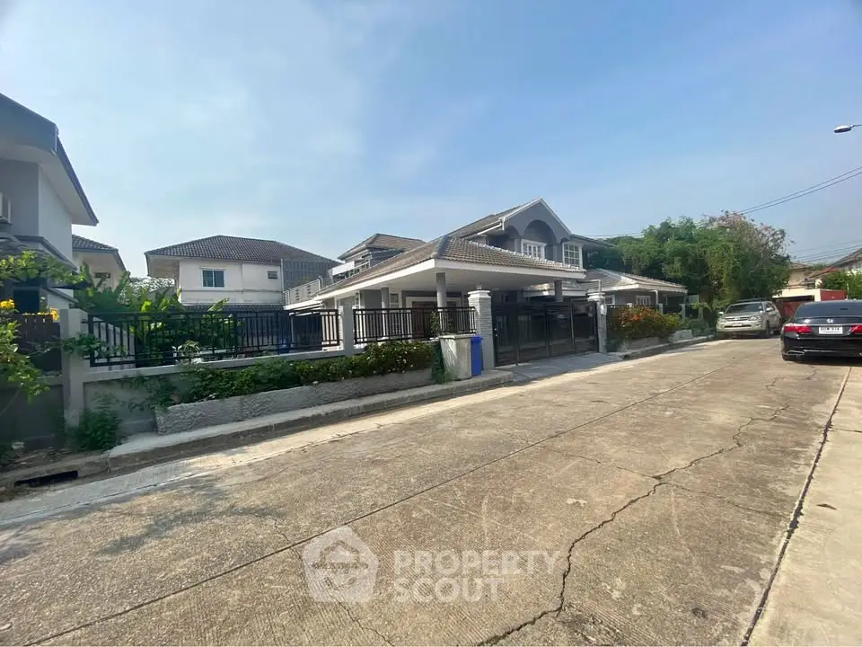 Charming suburban house with spacious driveway and lush greenery in a peaceful neighborhood.