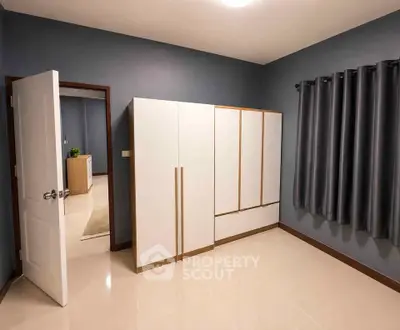 Spacious bedroom with modern wardrobe and sleek curtains in a stylish home.