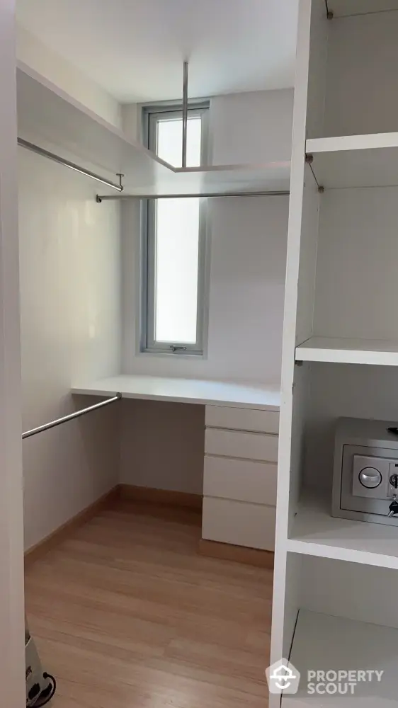 Spacious walk-in closet with built-in shelves and natural light