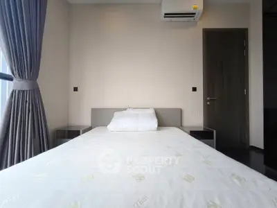 Modern bedroom with minimalist design, featuring a comfortable bed and elegant curtains, perfect for relaxation.
