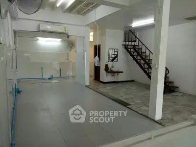 Spacious open-plan interior with staircase and tiled flooring, ideal for versatile use.