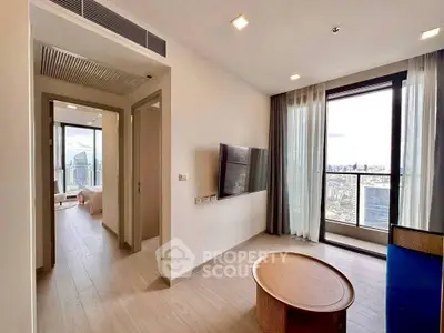 Modern living room with city view and sleek furniture in high-rise apartment.