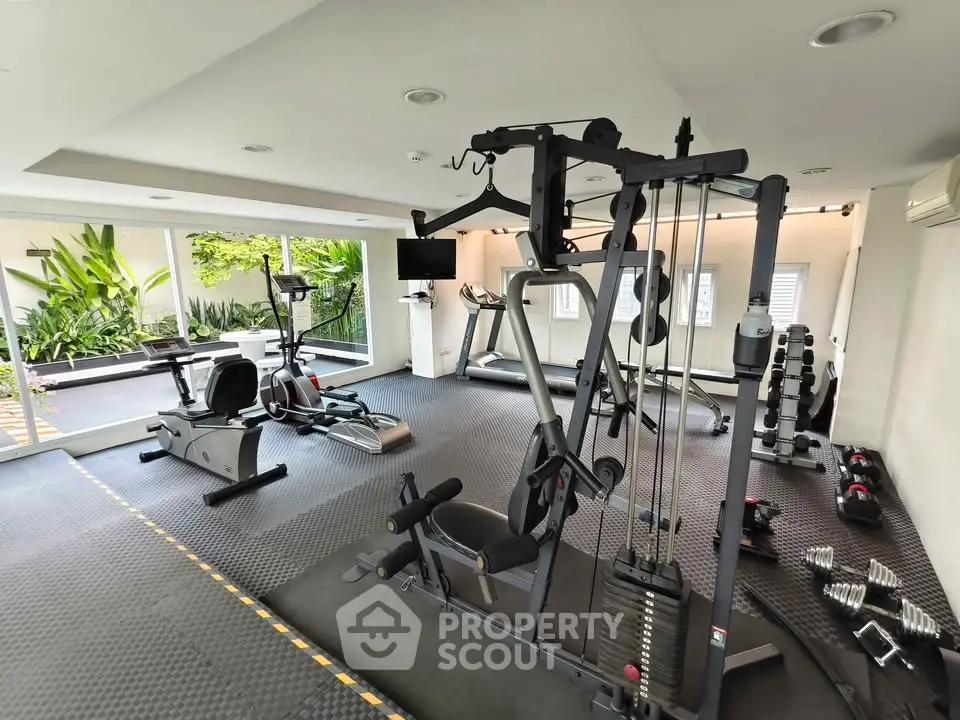 Modern gym with state-of-the-art equipment and lush garden view.