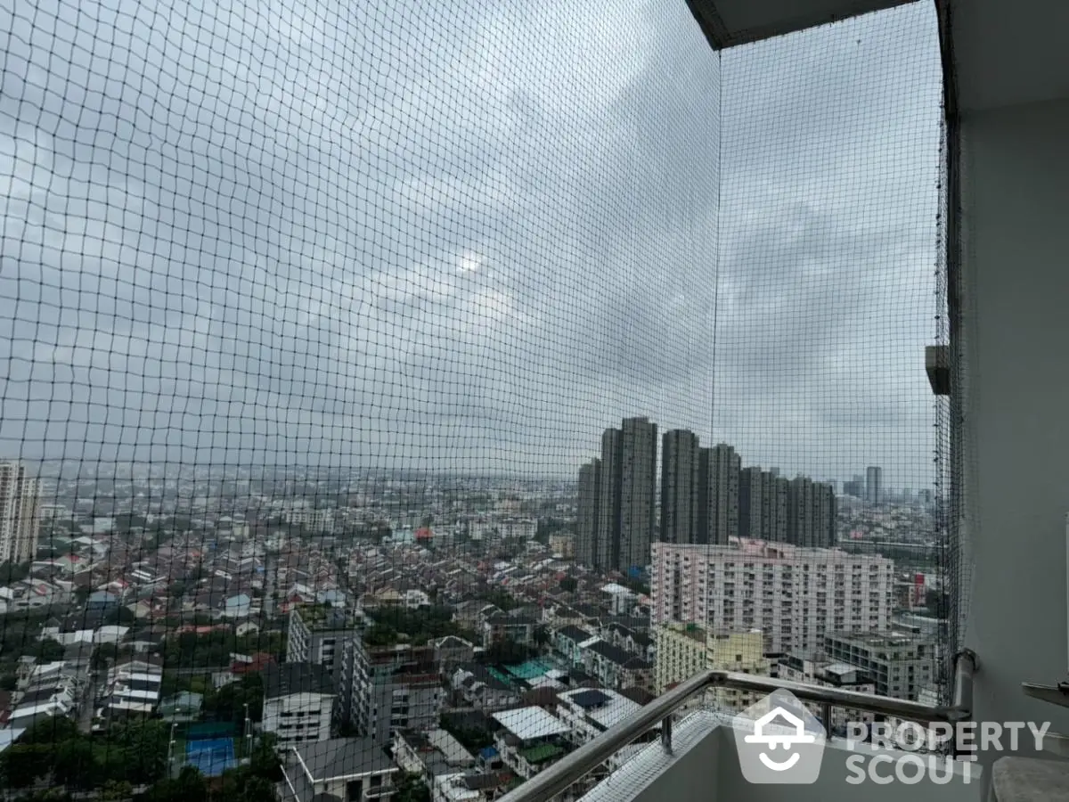 Stunning cityscape view from high-rise balcony with safety netting, perfect for urban living.