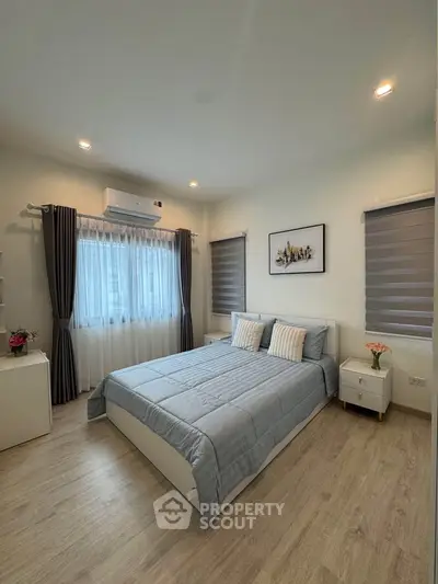 Modern bedroom with stylish decor and natural light, featuring a comfortable bed and elegant furnishings.