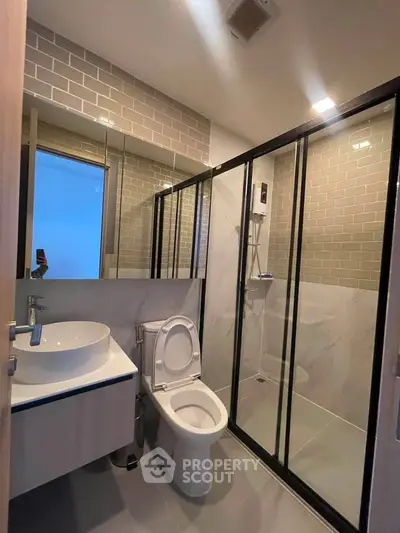 Modern bathroom with glass shower enclosure and stylish fixtures