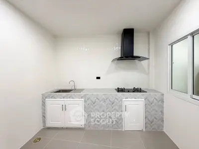 Modern kitchen with sleek gas stove and stylish cabinetry in a minimalist design.