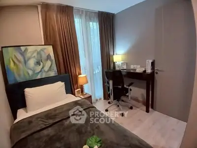 Cozy bedroom with study area, featuring modern decor and natural light.