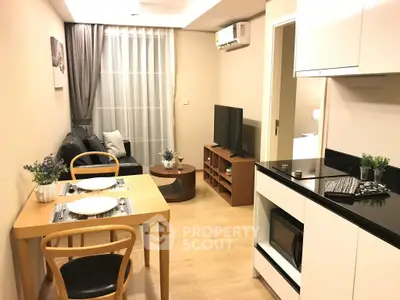 Modern living room with open kitchen, stylish furniture, and cozy ambiance in a contemporary apartment.