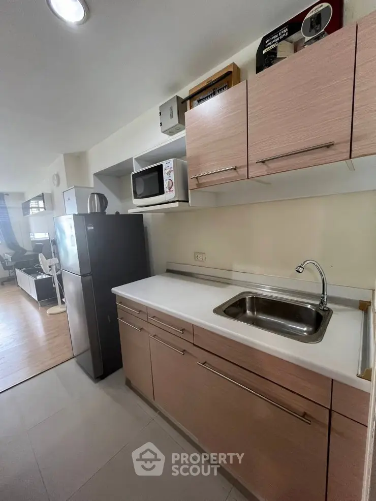 Modern kitchen with sleek cabinetry and stainless steel appliances in a stylish apartment.