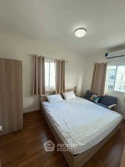 Cozy bedroom with wooden flooring and natural light