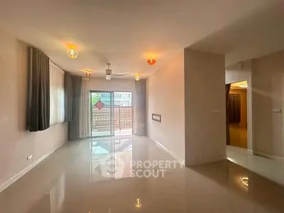 Spacious living room with modern lighting and large windows for natural light.