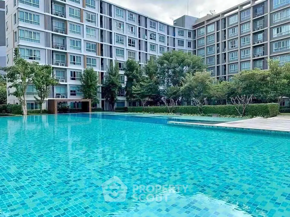 Luxurious condominium with a stunning pool and lush greenery, perfect for modern living.