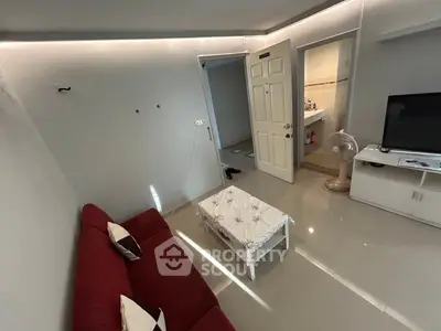 Cozy living room with red sofa, modern decor, and sleek flooring in a stylish apartment.