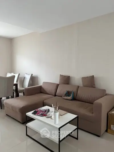 Spacious living room with modern brown sofa and elegant dining area, perfect for family gatherings.