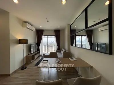 Modern living room with city view, featuring sleek furniture and large windows for natural light.