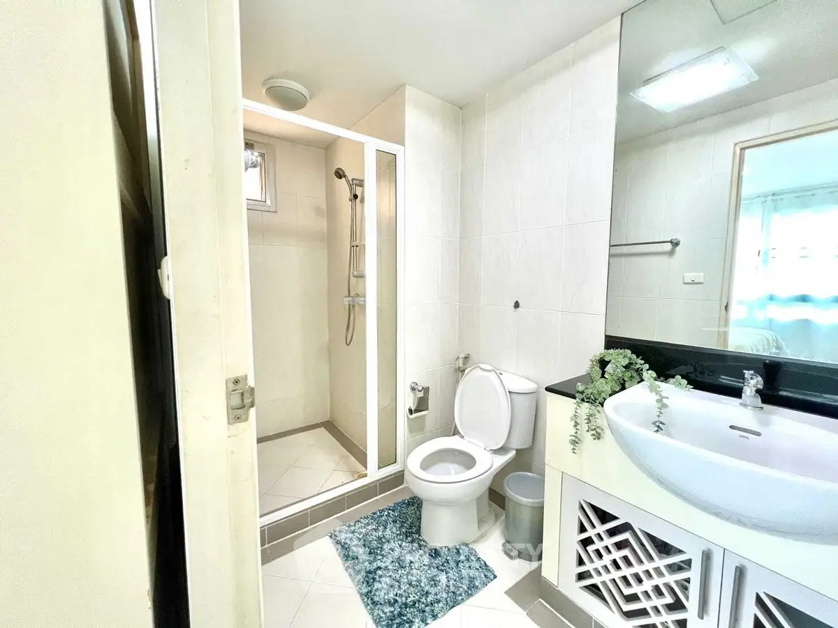 Modern bathroom with shower, toilet, and stylish vanity in bright, clean design.