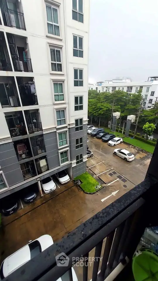 Modern apartment building with parking lot view, showcasing urban living convenience.