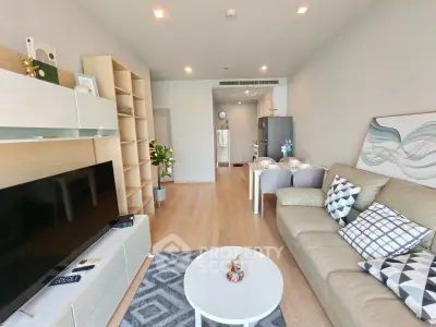 Modern living room with stylish decor and open layout, featuring a cozy sofa and entertainment center.